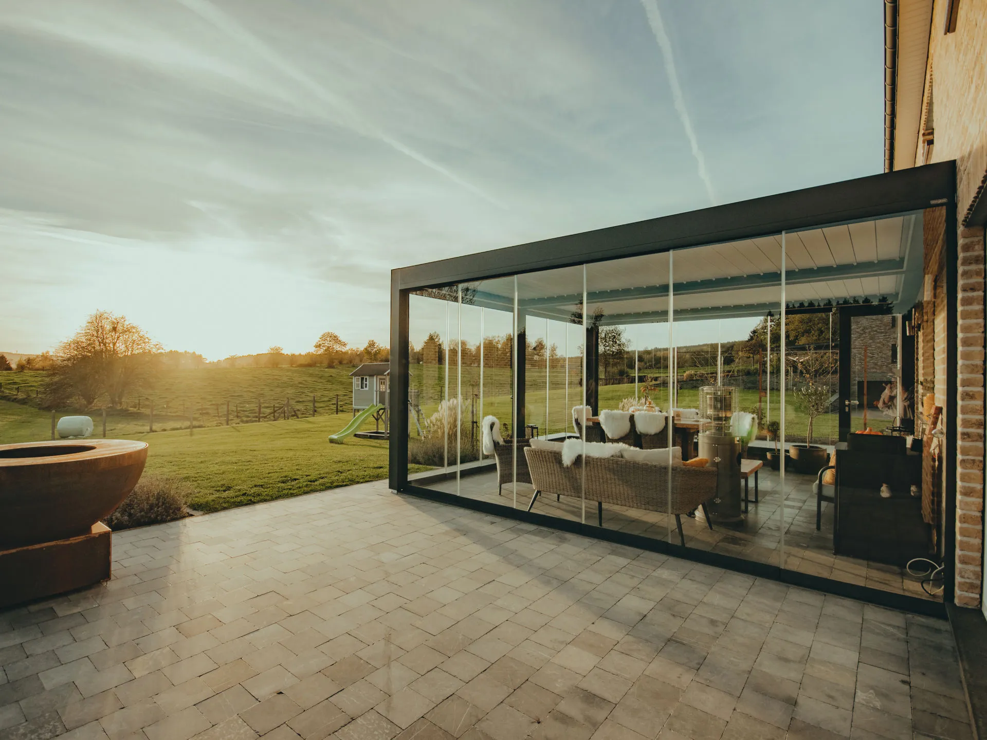 Cerramiento de cristal con pérgola de aluminio al atardecer
